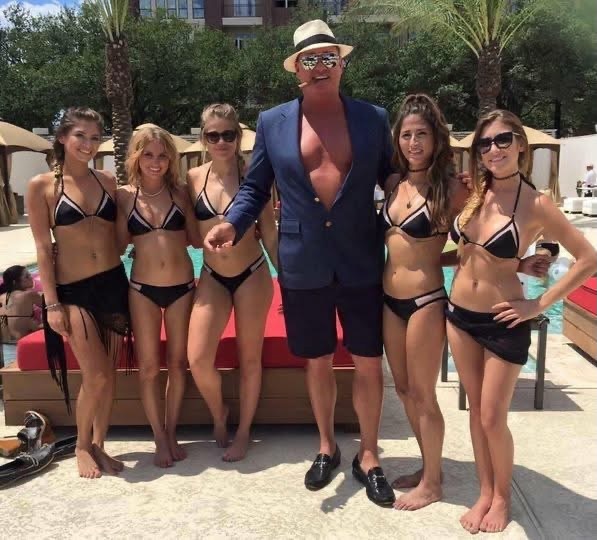Phil in a navy jacket posing with a group by the pool