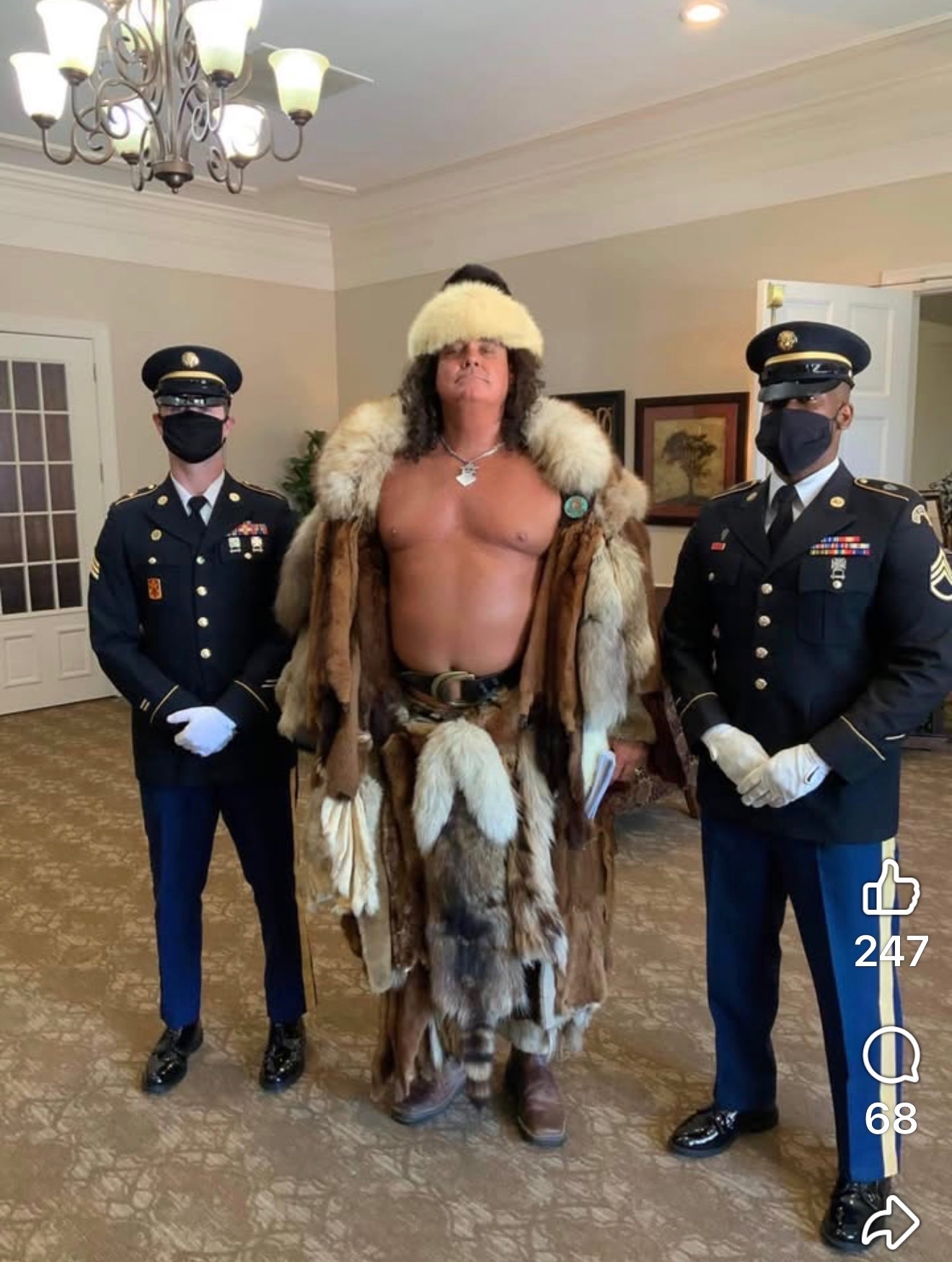Phil in a fur costume standing between two uniformed service members